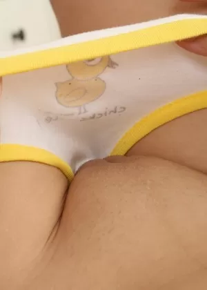 Молодо выглядящая девушка Доминика раздевается до разноцветных носков OTK на диване