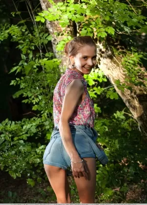 Стройная подросток Алисабель снимает комбинезон для великолепных обнаженных поз среди деревьев