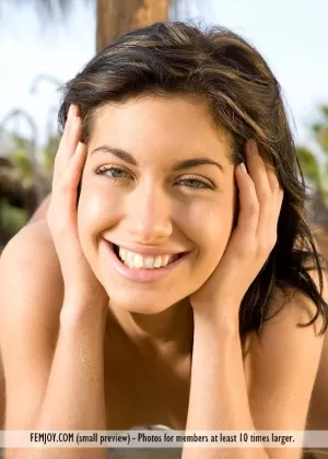 Стройная брюнетка с черными волосами едет на велосипеде на пляж, чтобы насладиться обнаженной