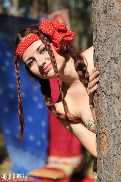 Симпатичная рыжеволосая Джулли раздевается догола в лесу, ее волосы заплетены 