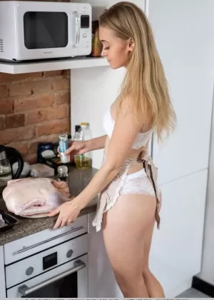 Молодая модель Клара позирует полностью обнаженной, готовя что-нибудь поесть