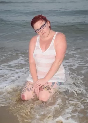 Зрелая рыжая Молли Фокс смачивает свое татуированное тело в океане