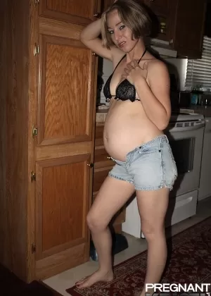 Беременная соло-девушка Брианна моделирует голышом на своей кровати в носках для рук