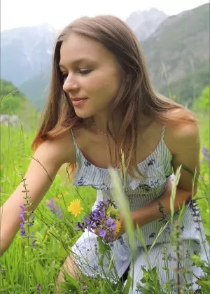 Симпатичная девушка полностью раздевается на одеяле на альпийском склоне