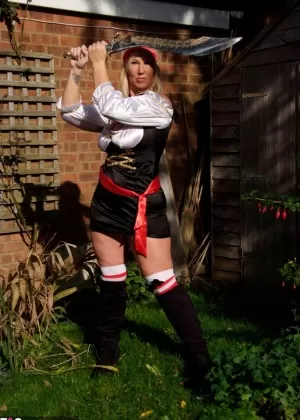 Fat blonde Melody frees her large boobs in a yard while sporting cosplay gear