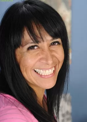 Зрелая темноволосая соло девушка демонстрирует красивую попку и бобер в чулках