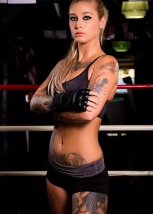 Татуированная милфа порнозвезда Клейо Валентьен в шортах показывает большие сиськи в спортзале