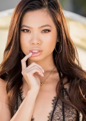 Миниатюрная тайская девушка завернута в боа из перьев, показывая свою подстриженную киску