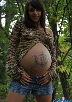 Беременная девушка Мартина стоит голая, насколько это возможно, сняв всю свою одежду