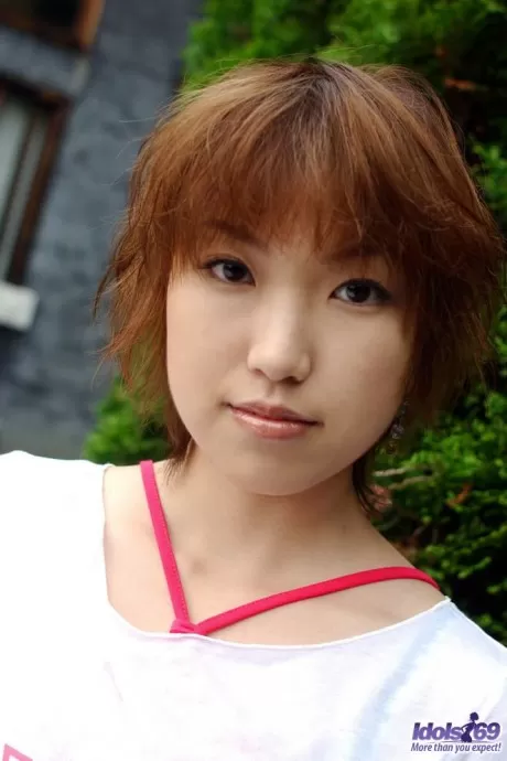 Рыжая японка Мадока кладет руку на свою пизду после того, как обнажила свои сиськи