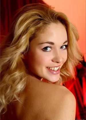 Белокурая модель с красивой попкой и задницей позирует полностью обнаженной в гостиной