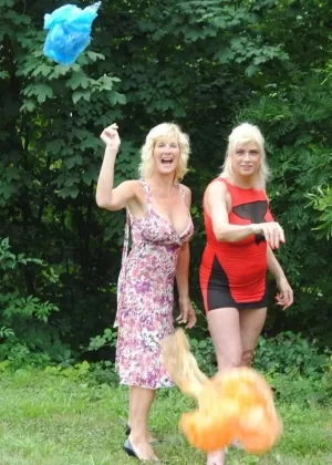 Одетая девушка Саша садится на корточки, чтобы пописать за бетонным блоком на дорожке