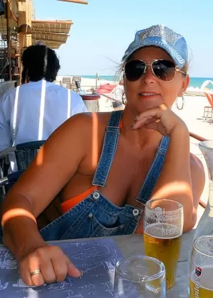 Белокурая любительница Катерина Хартлова обнажает свои огромные сиськи на скамейке в парке в чулках