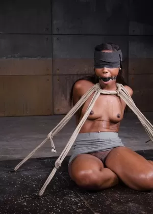 Рыжая с завязанными глазами щеголяет кляпом во рту, будучи скованной в своей одежде