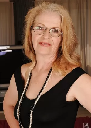 Пожилая любительница обнажает свои отвисшие сиськи, раздеваясь на каблуках