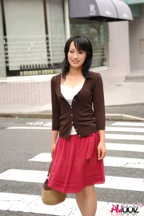 Японская красавица Мио Канна прогуливается по центру города в юбке до колен