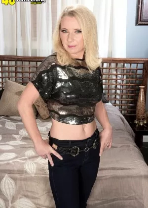 Миниатюрная блондинка средних лет Нэнси Джей раздевается, чтобы увидеть нижнее белье перед своей кроватью