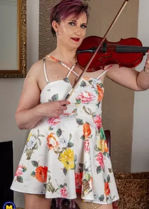 Длинноногая любительница расстегивает молнию, чтобы позировать обнаженной в туфлях на высоких каблуках