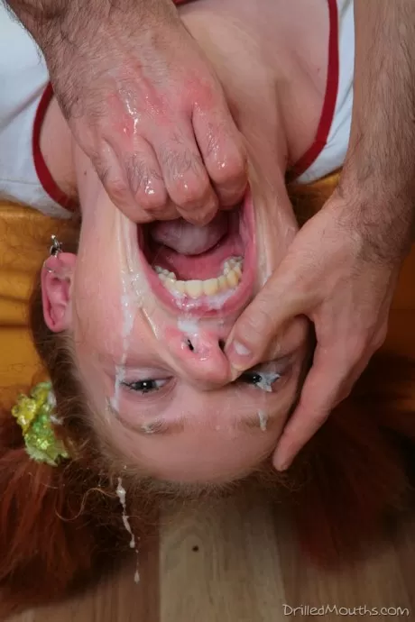 У молодой рыжей девушки широко раскрыт рот во время грязного минета