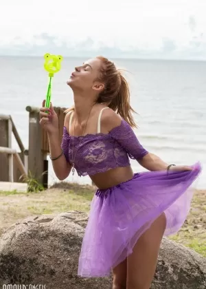 Молодо выглядящая рыжеволосая Ингрид снимает свой прозрачный наряд, чтобы позировать обнаженной на камне