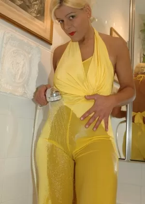 Блондинка-любительница Мартина снимает желтый комбинезон во время купания