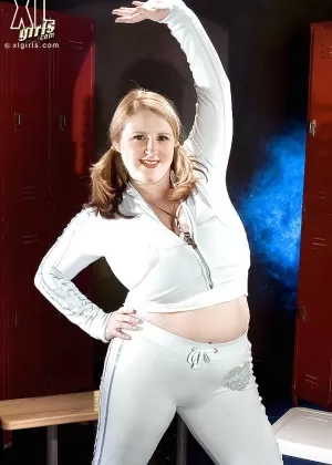 Очаровательная толстушка занимается спортом и раздевается топлесс в тренажерном зале